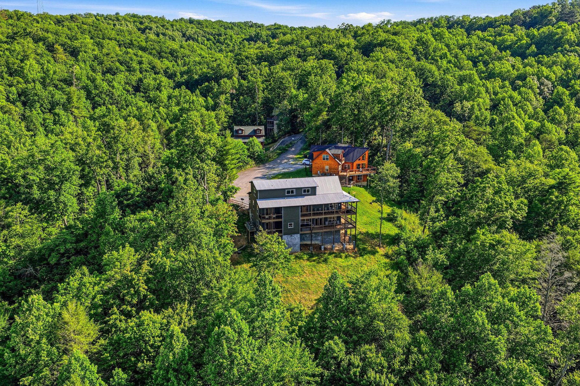 The property sits nestled among rolling wooded hills, offering a peaceful, secluded escape surrounded by nature. Ample parking and a quiet neighborhood setting make arrival effortless and serene.