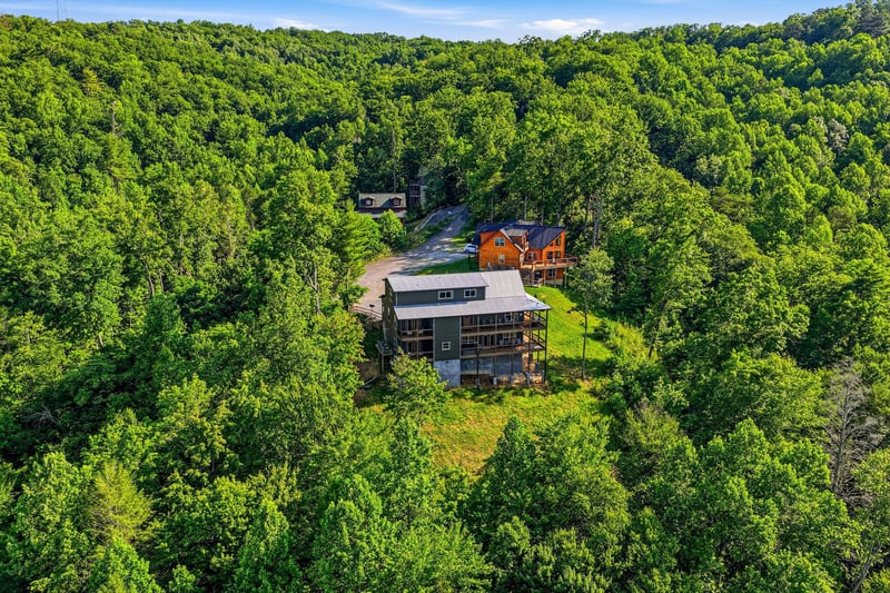The property sits nestled among rolling wooded hills, offering a peaceful, secluded escape surrounded by nature. Ample parking and a quiet neighborhood setting make arrival effortless and serene.