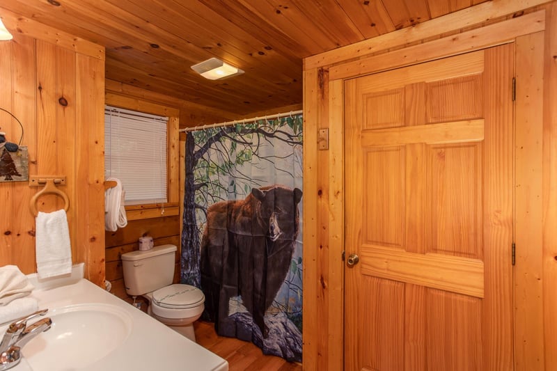 Toilet beside shower with bear shower curtain
