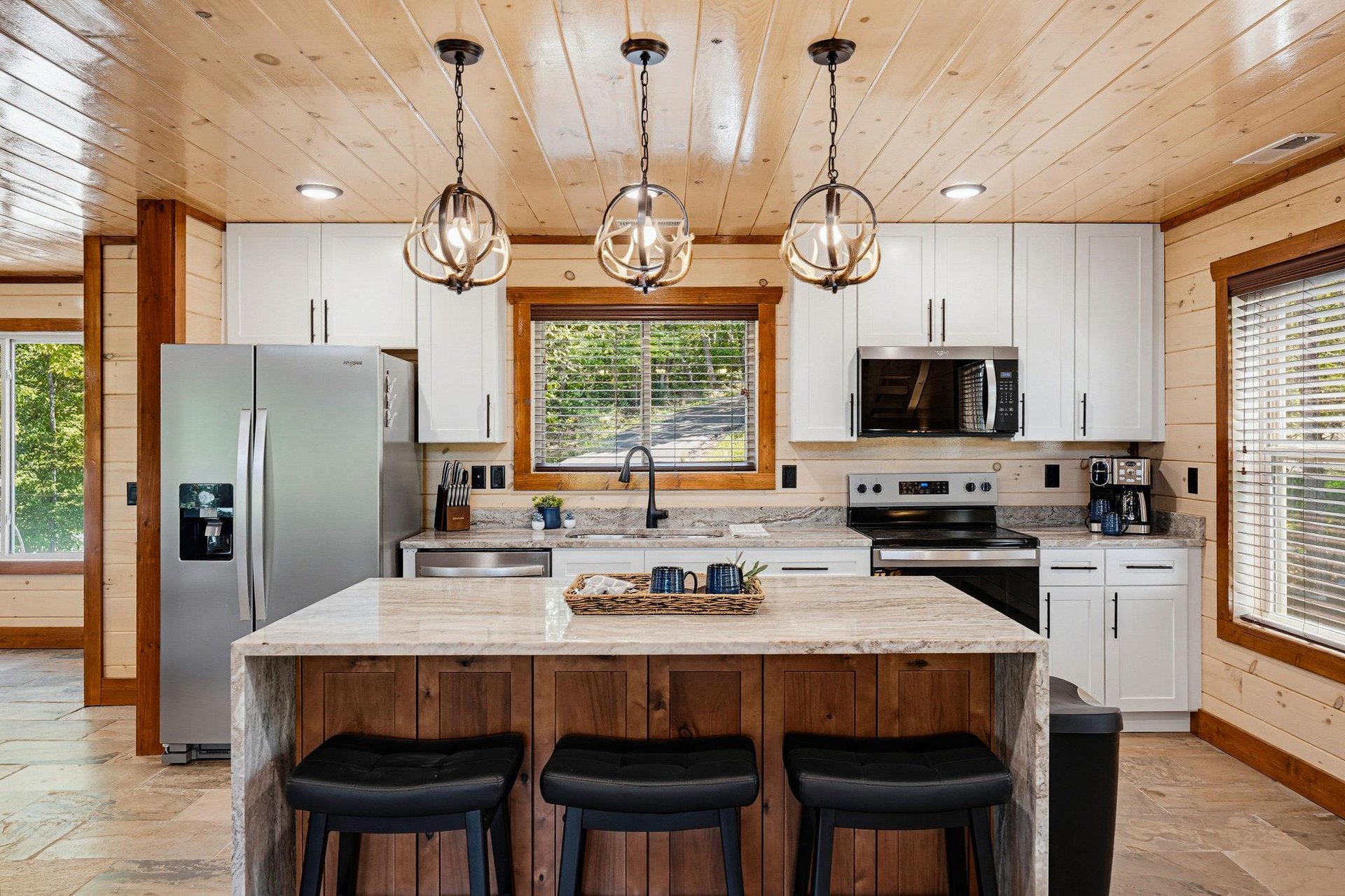 Step into your fullyequipped kitchen, where rustic wood meets modern convenience. Gather at the center island, cook your favorite meals, and enjoy the warm natural light streaming through the windows