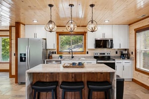 Step into your fullyequipped kitchen, where rustic wood meets modern convenience. Gather at the center island, cook your favorite meals, and enjoy the warm natural light streaming through the windows