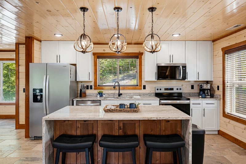 Step into your fullyequipped kitchen, where rustic wood meets modern convenience. Gather at the center island, cook your favorite meals, and enjoy the warm natural light streaming through the windows