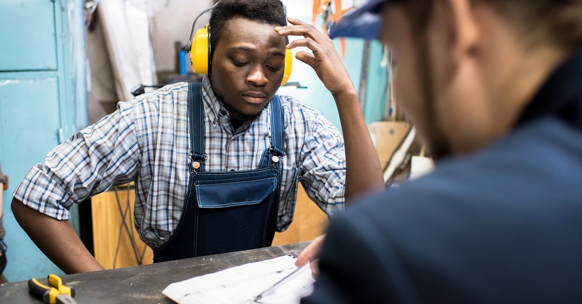 Concentrated manual worker listening to plan of boss