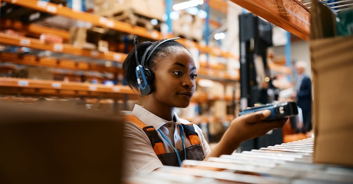Young black woman scanning packages while working in warehouse