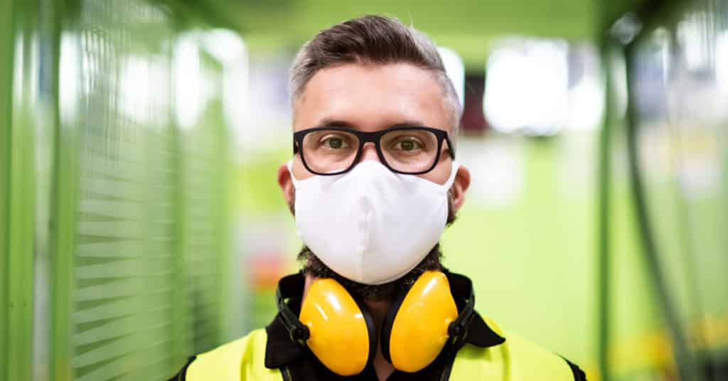 Worker with protective mask in industrial setting