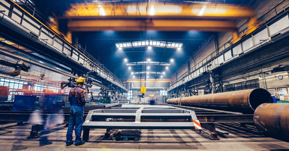 Large factory hall with blue collar workers at work