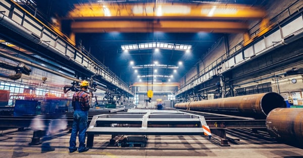 Large factory hall with blue collar workers at work