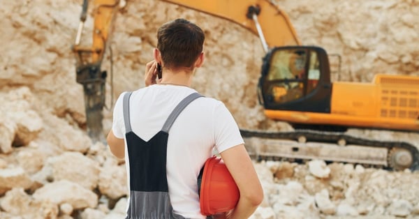 Operator working on equipment in a borrow pit