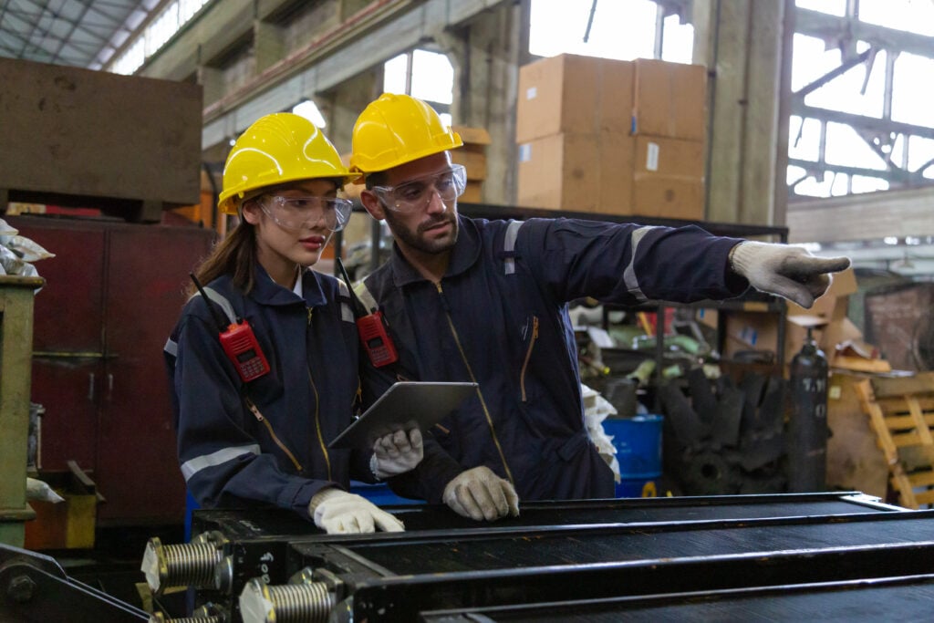 Maintenance technicians verifying asset records on a tablet in the field