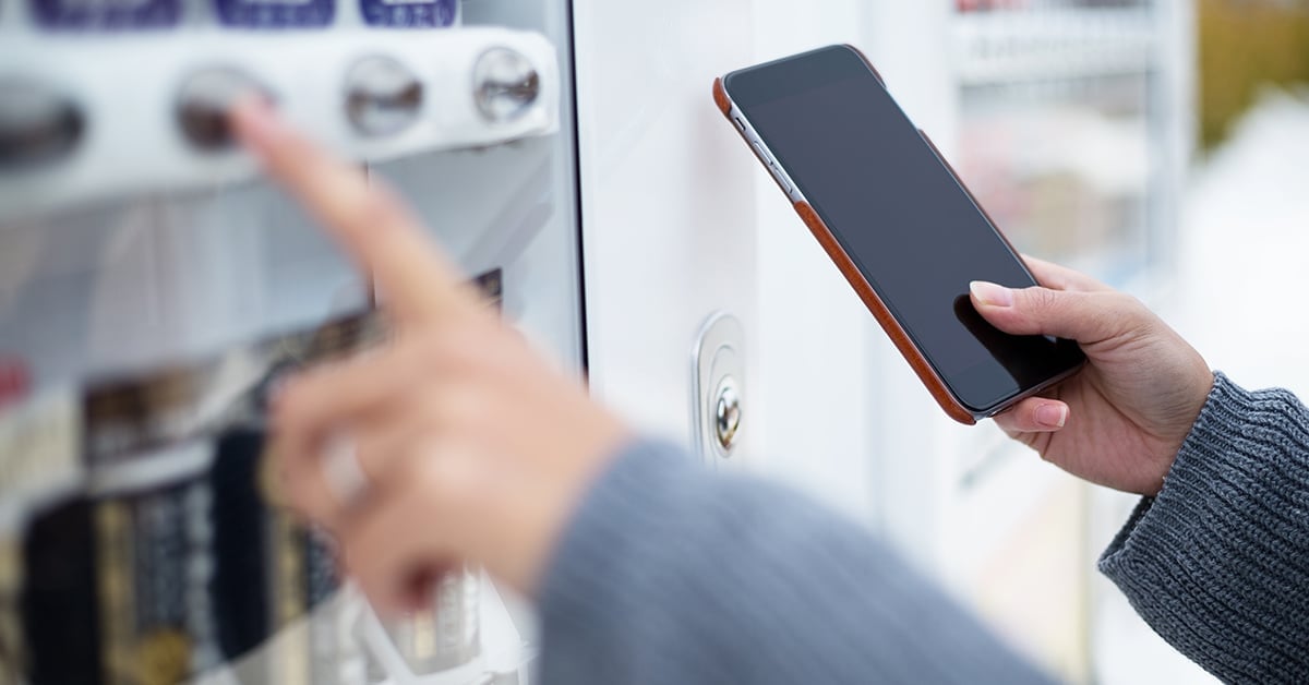Woman using NFC technology at a vending machine