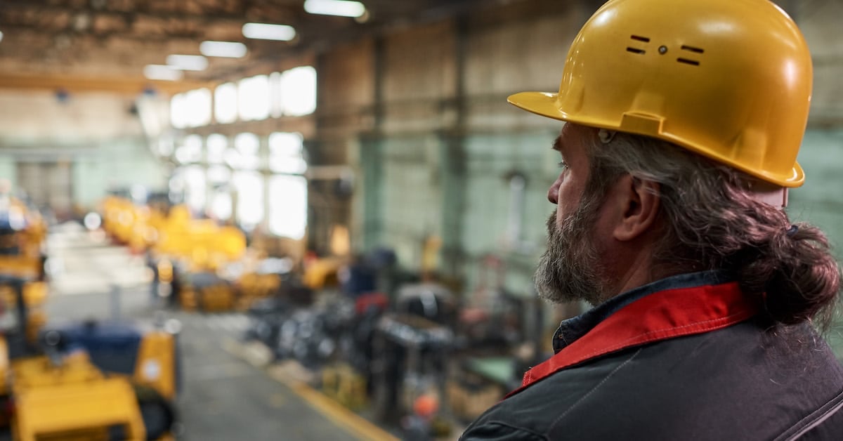 Foreman in hardhat working in factory
