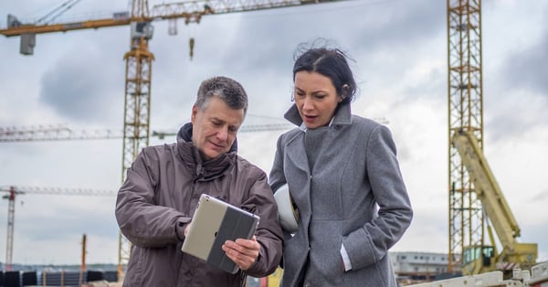 Two engineers, male and female, on a construction site