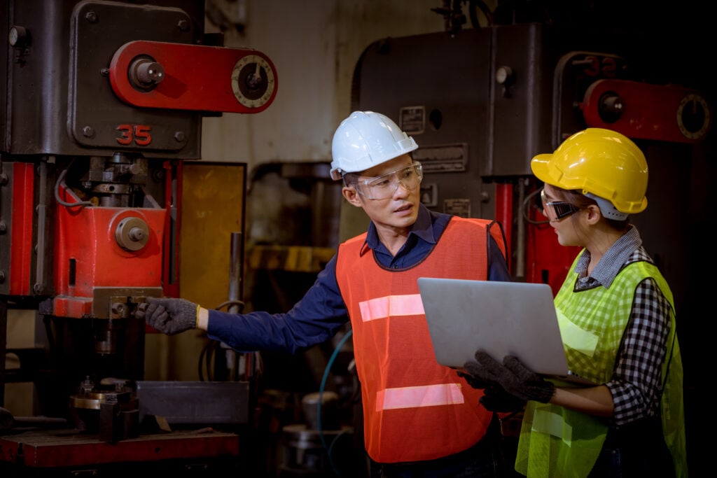 Engineer in safety uniform operating equipment controls