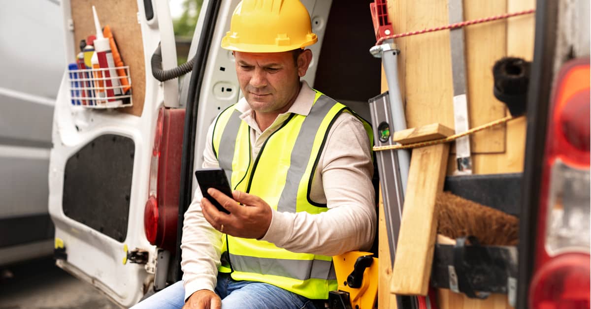 Construction worker using smartphone near the site