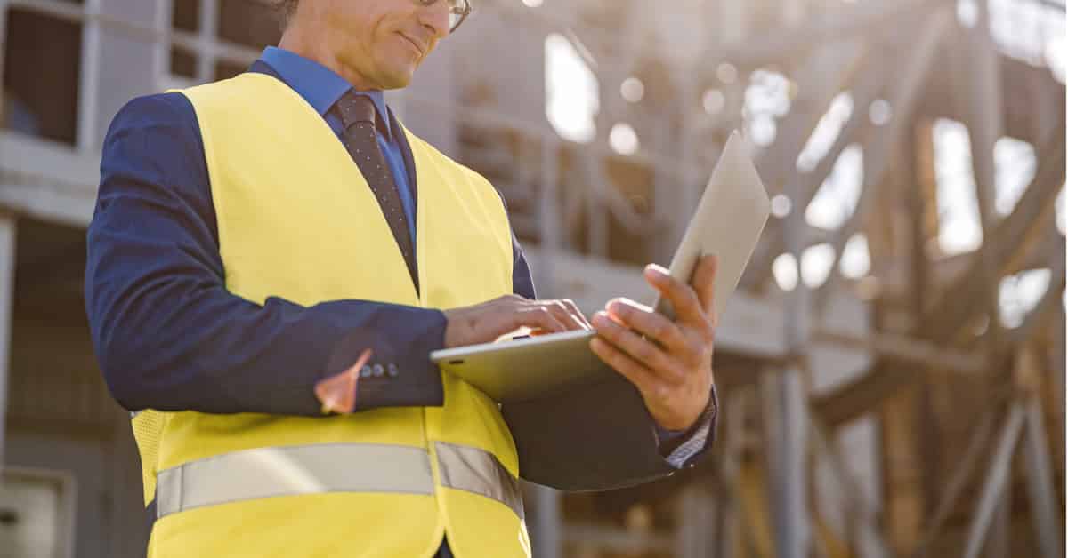Male engineer working on notebook outdoors at a factory
