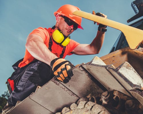 Heavy equipment mechanic performing maintenance