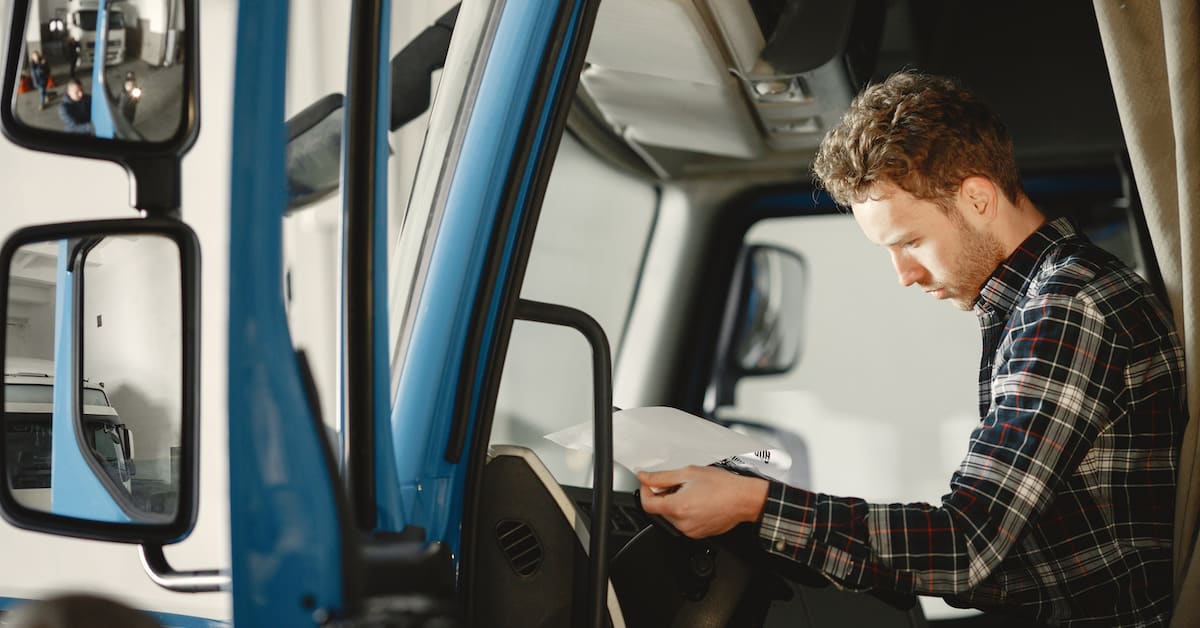 Driver of blue truck using a smartphone in the field
