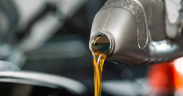 Partial view of pouring oil from bottle