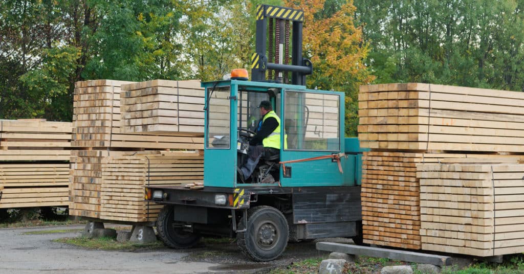 Forklift transports boards at a manufacturing plant