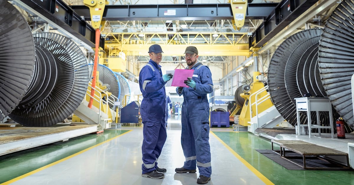 Engineers in discussion in turbine maintenance facility
