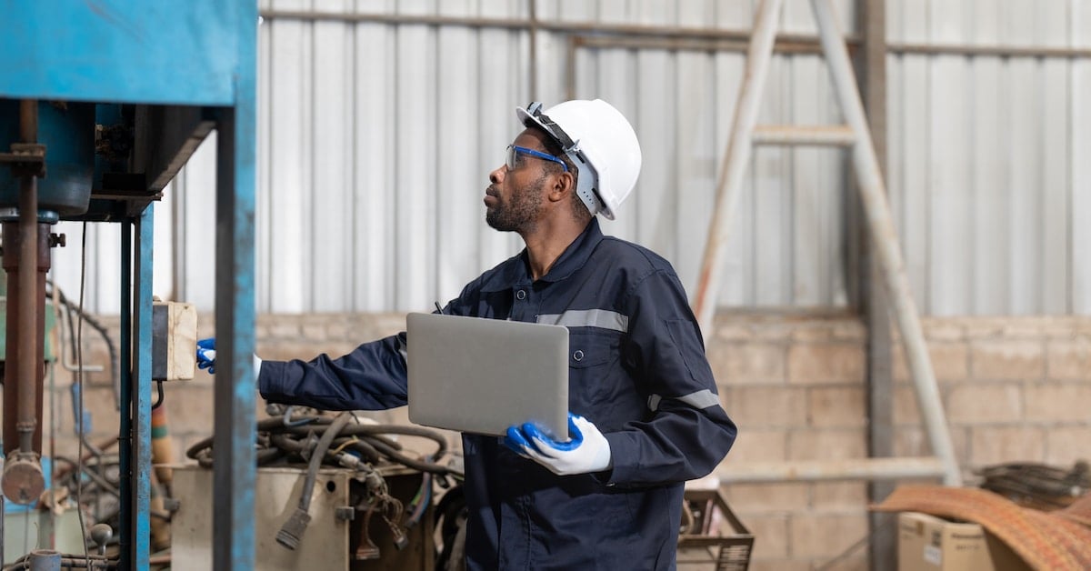 Male engineer in uniform using laptop for inspection
