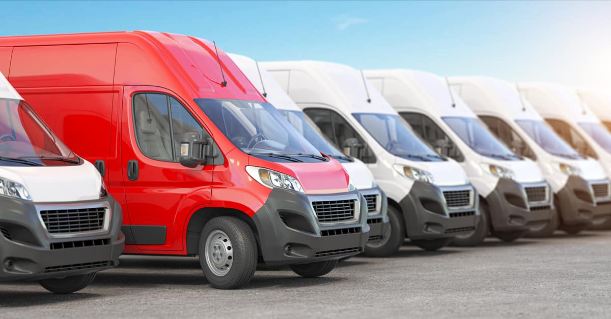 Red delivery van in a row of white vans
