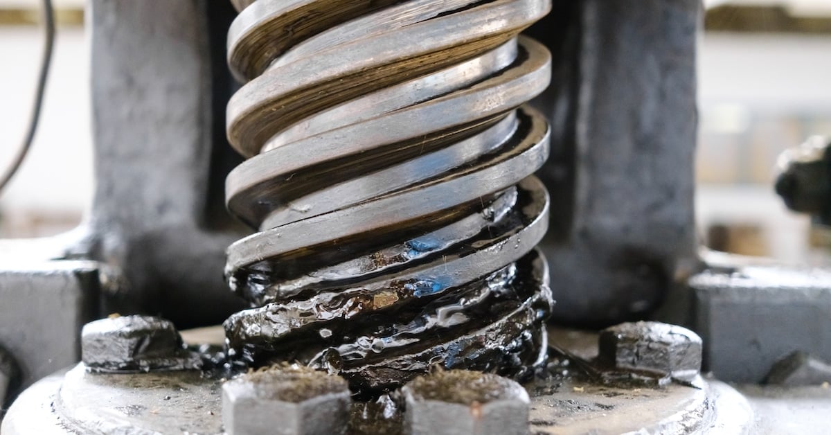 Industrial manual spindle press detail showing grease lubrication