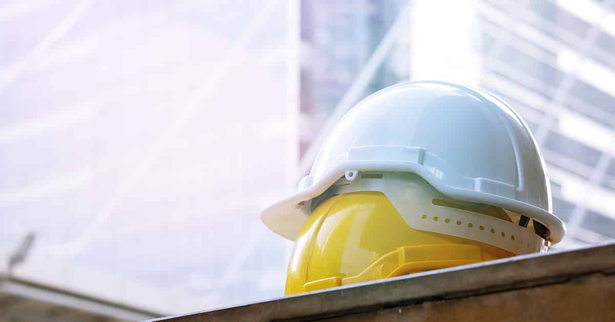 Safety hard hat on building background