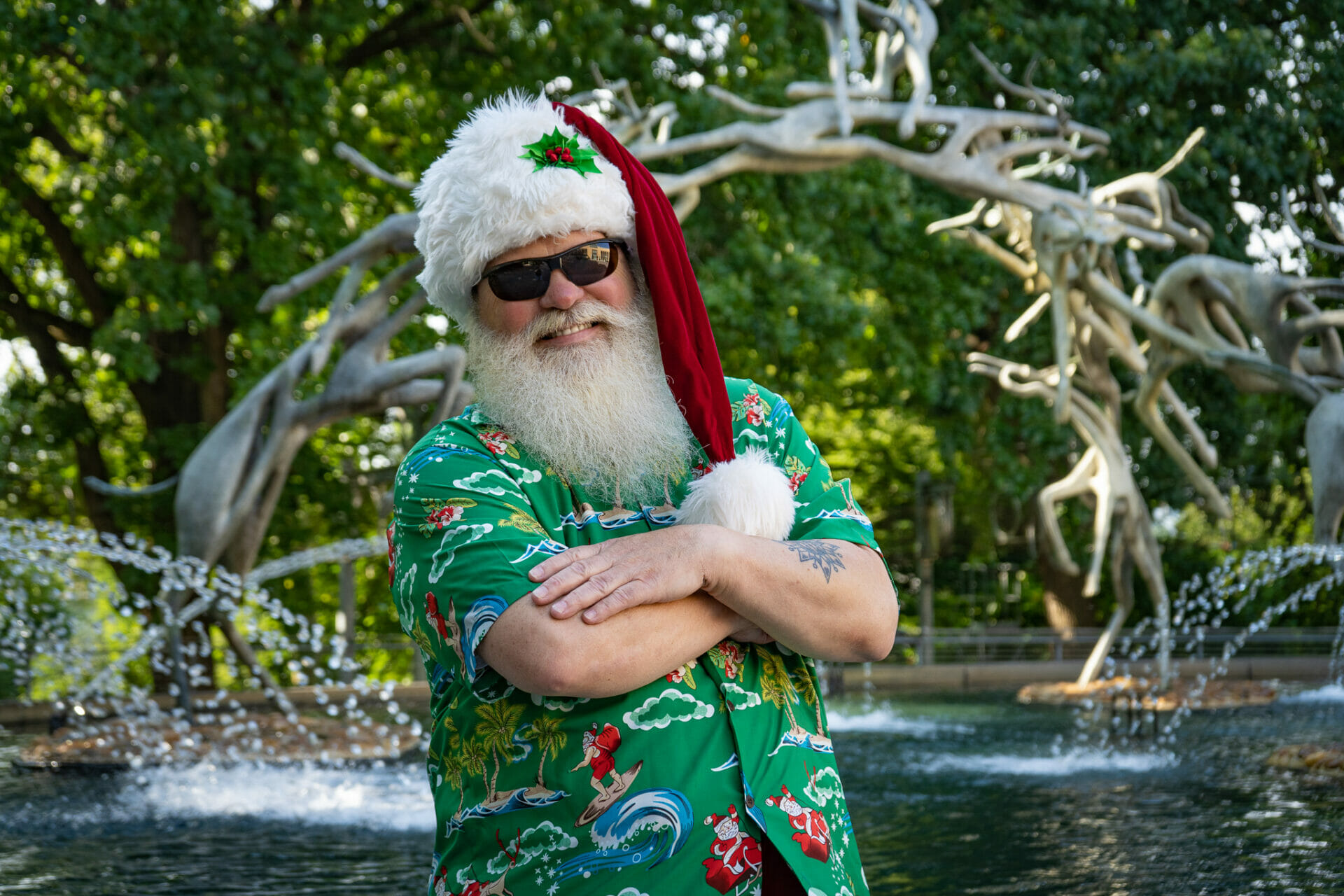 Santa poses in front of Impala Fountain at Philadelphia Zoo as part of the Zoo's Christmas in July event.