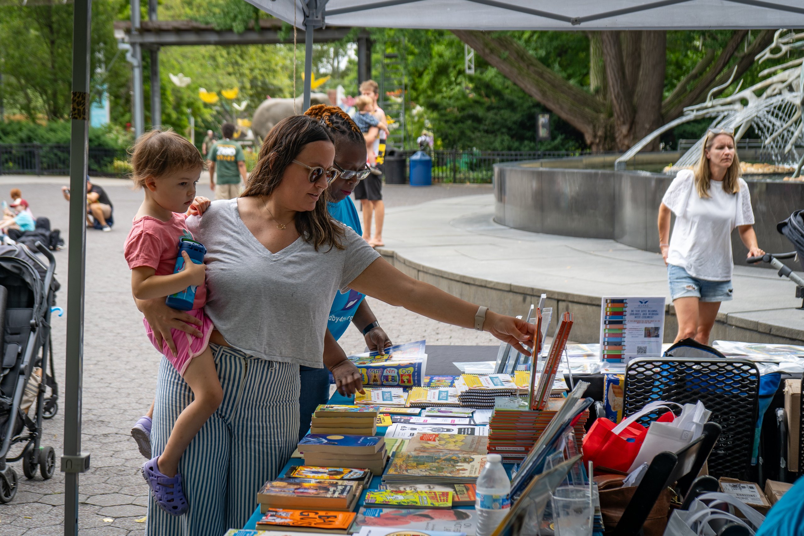 Guests receive free books from the West Philly Reading Captains during African Culture Fest at Philadelphia Zoo.