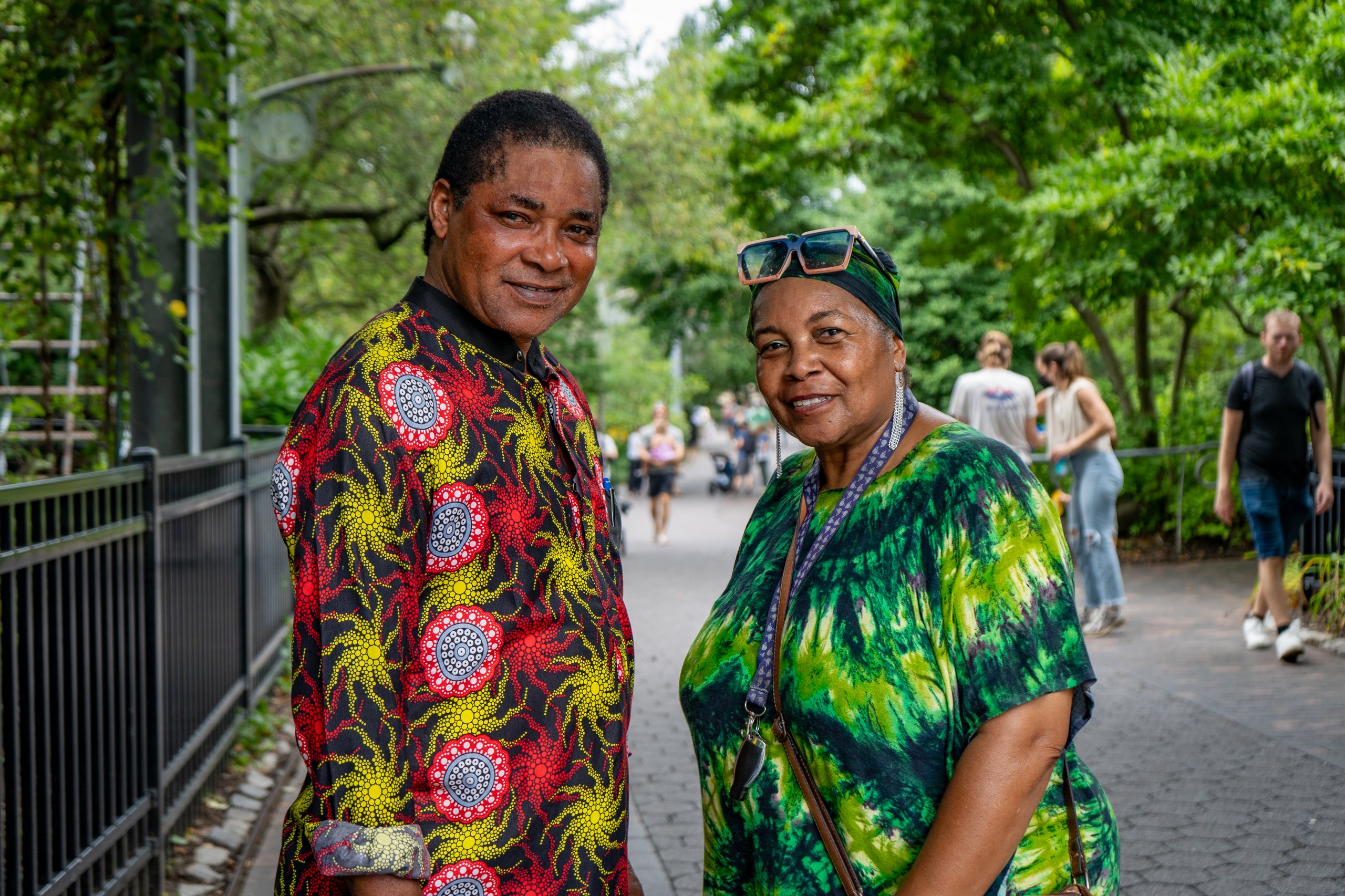 Two guests wearing traditional African garments pose for a photo on the Zoo path during African Culture Fest.