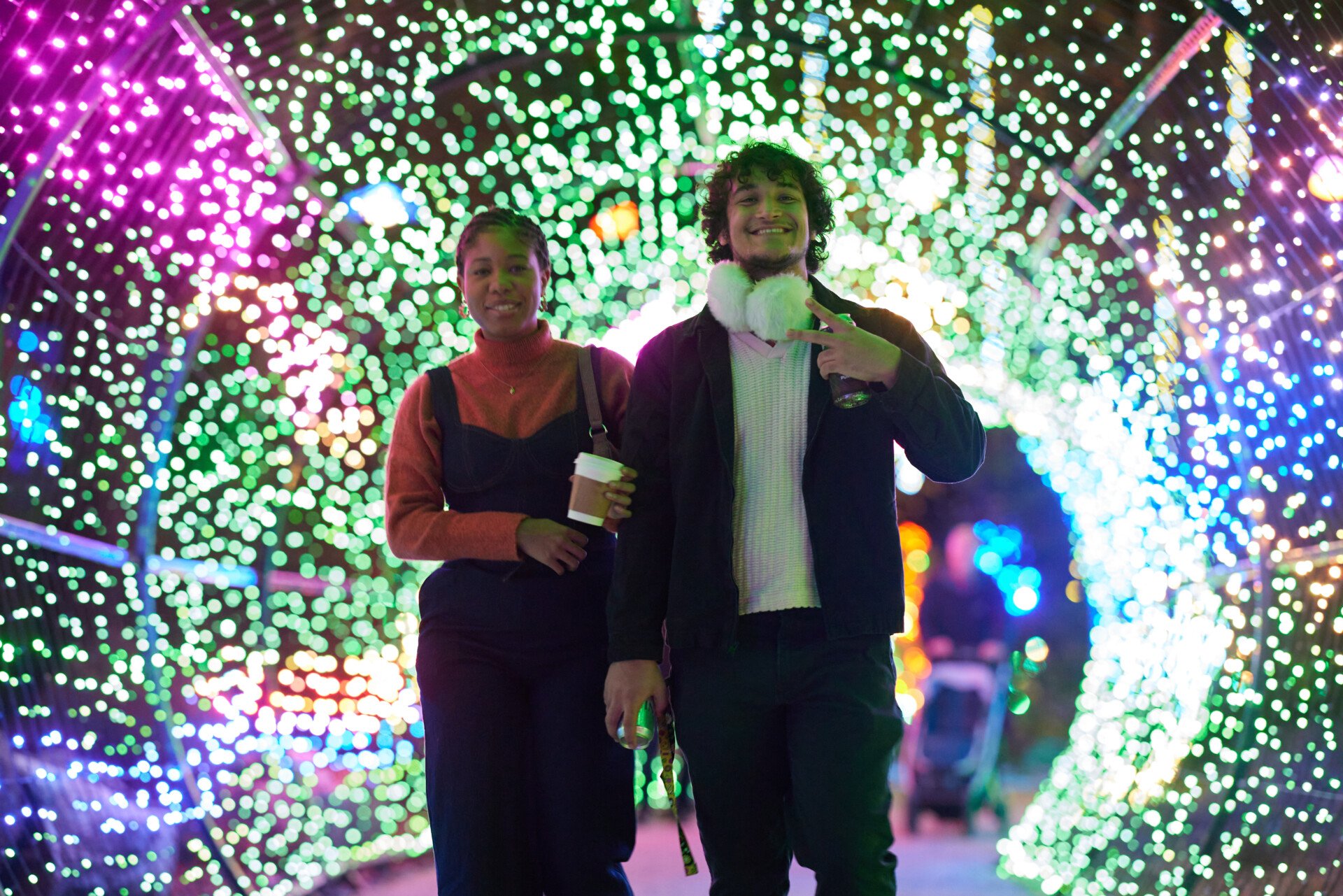 A couple poses inside a tunnel of lights at Philadelphia Zoo's LumiNature holiday light show.