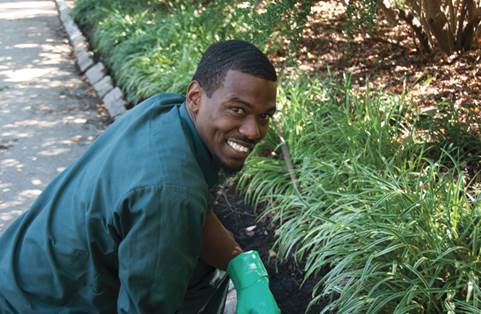 A Garden Services staff member smiles while tending to a garden bed at Philadelphia Zoo.