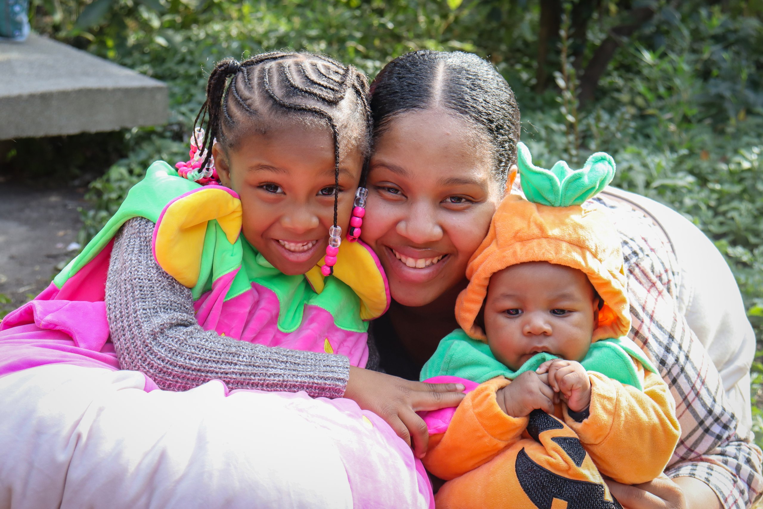 A mother and her two children, all dressed in Halloween costumes, smile for a photo during Boo at the Zoo at Philadelphia Zoo.