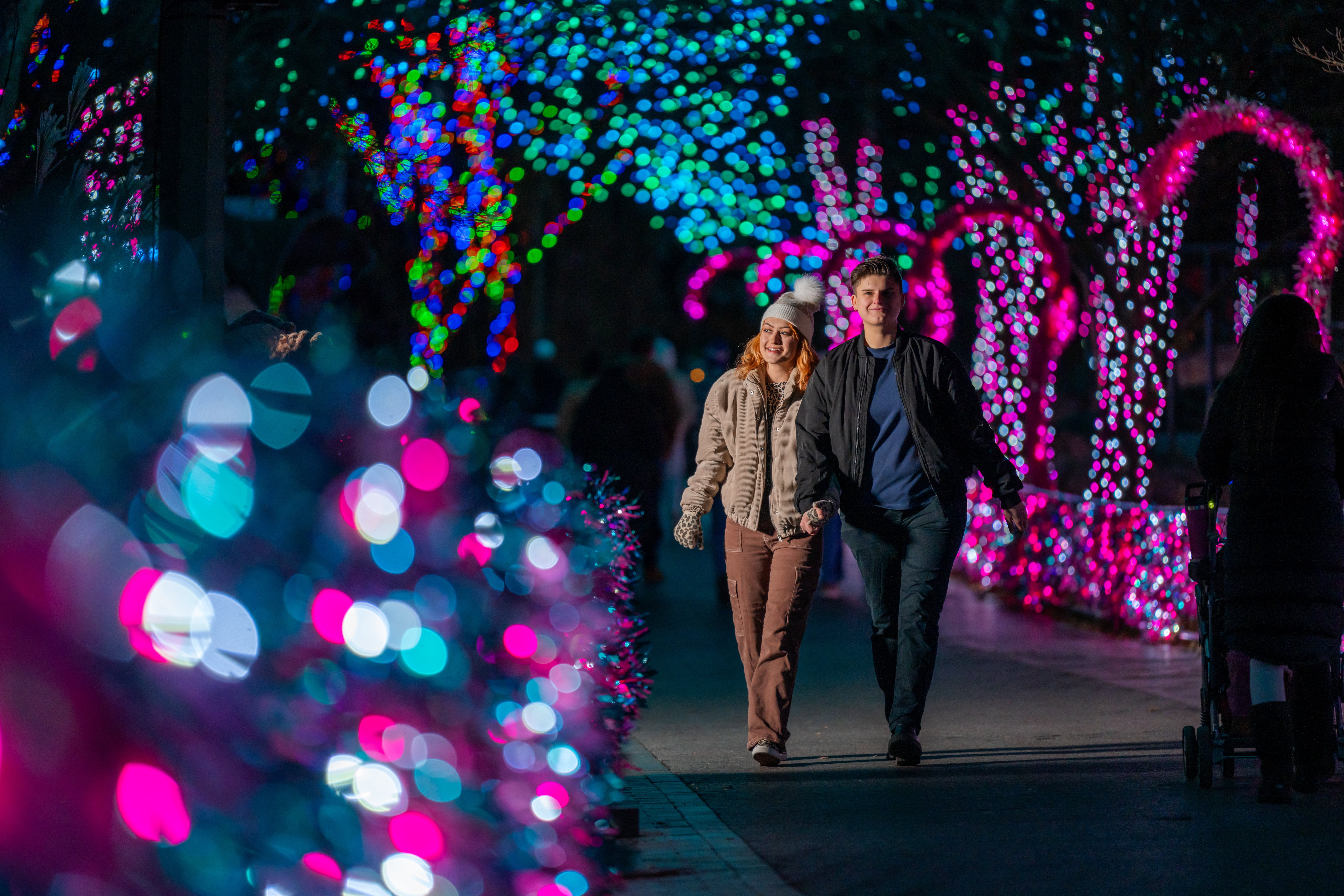 A couple walks down the main path at LumiNature, Philadelphia Zoo's holiday light show.