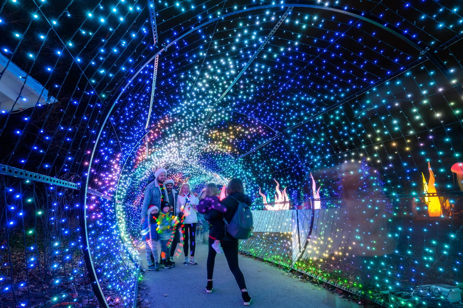 A family poses for a photo in the light tunnel at Philadelphia Zoo's LumiNature holiday light show.