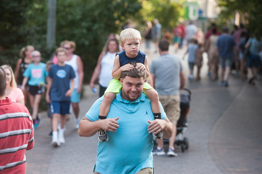 A child sits on top of his father's shoulders as they stroll the gardens of the Philadelphia Zoo.