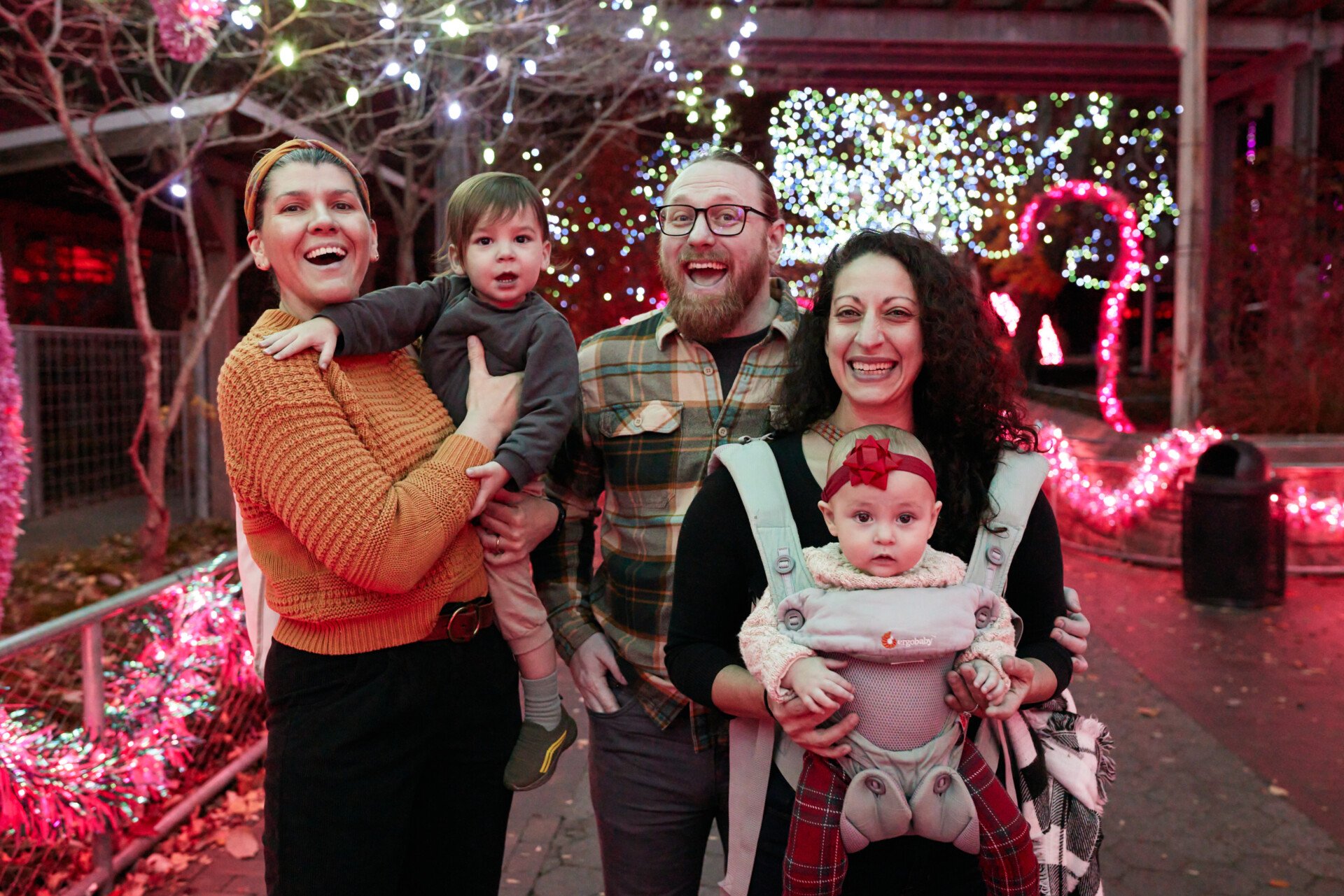 A family poses in Flamingo Fancy at Philadelphia Zoo's LumiNature holiday light show.