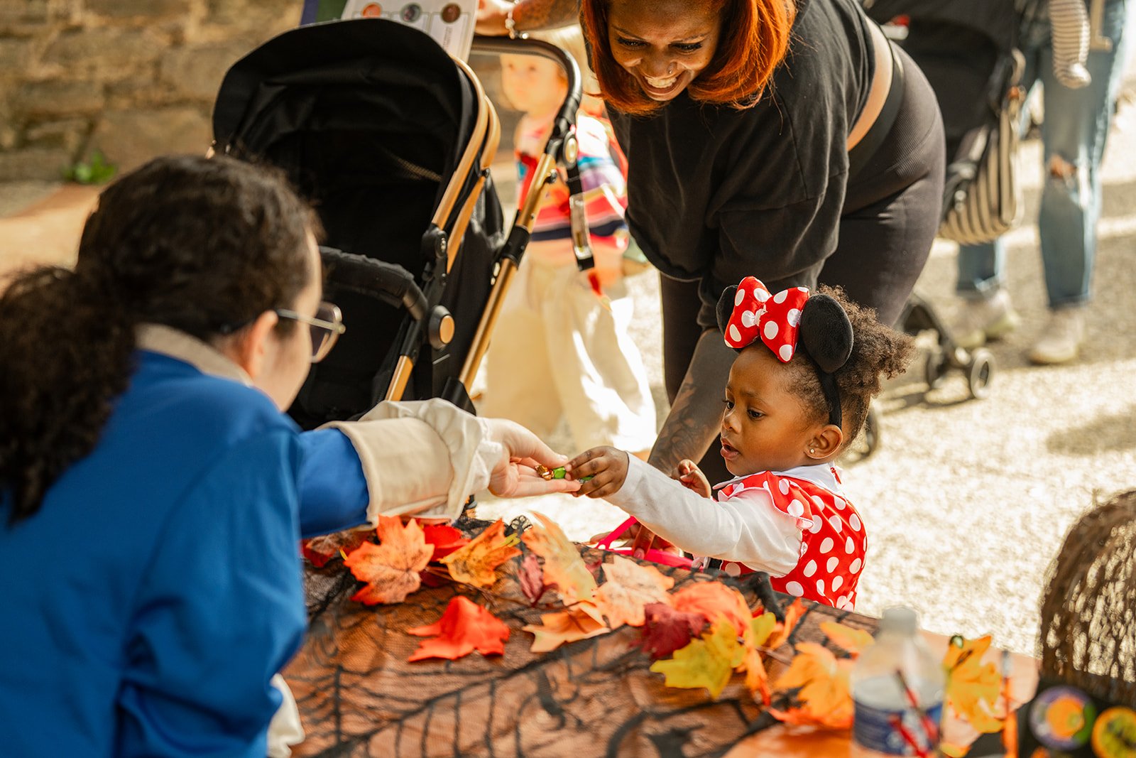 A child dressed as Minnie Mouse collects a piece of candy at a trick-or-treat station during Boo at the Zoo, Philadelphia Zoo's annual Halloween event.