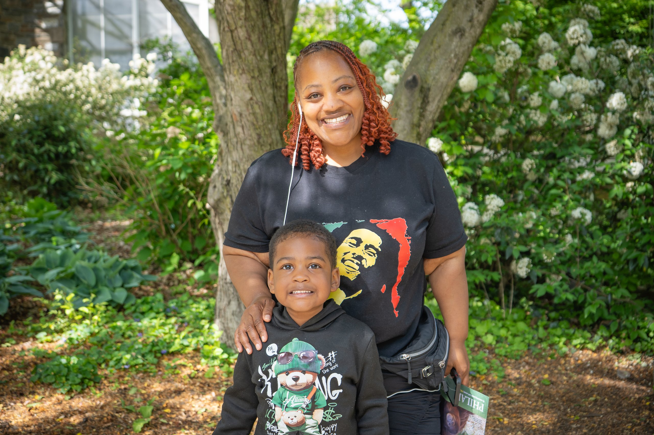 A mother and son smile for a photo in the gardens of Philadelphia Zoo.
