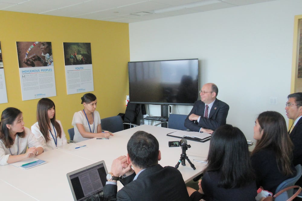 部屋で複数名が会議をしている写真。