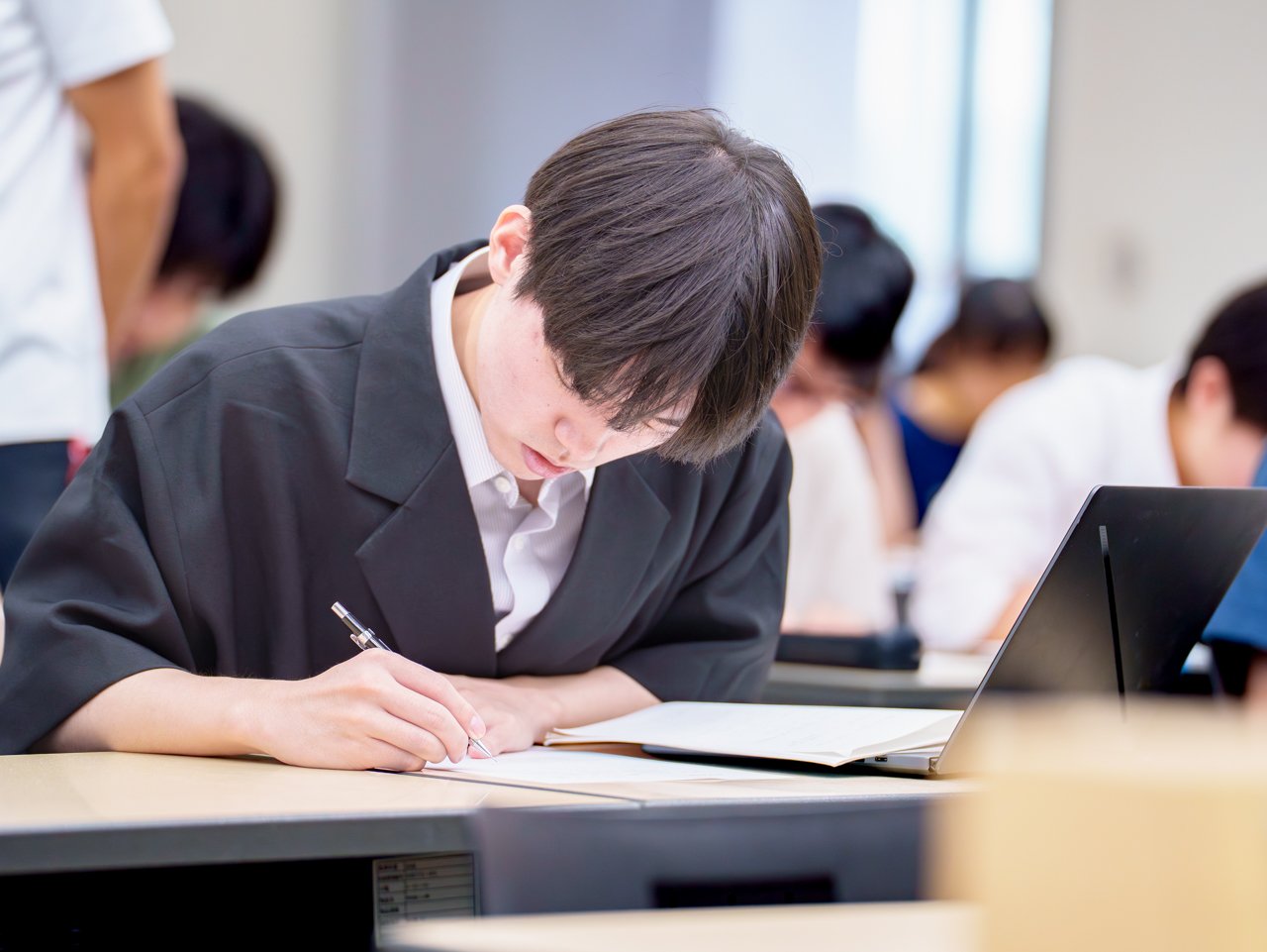 A photo of a student diligently working through paper-based problems.