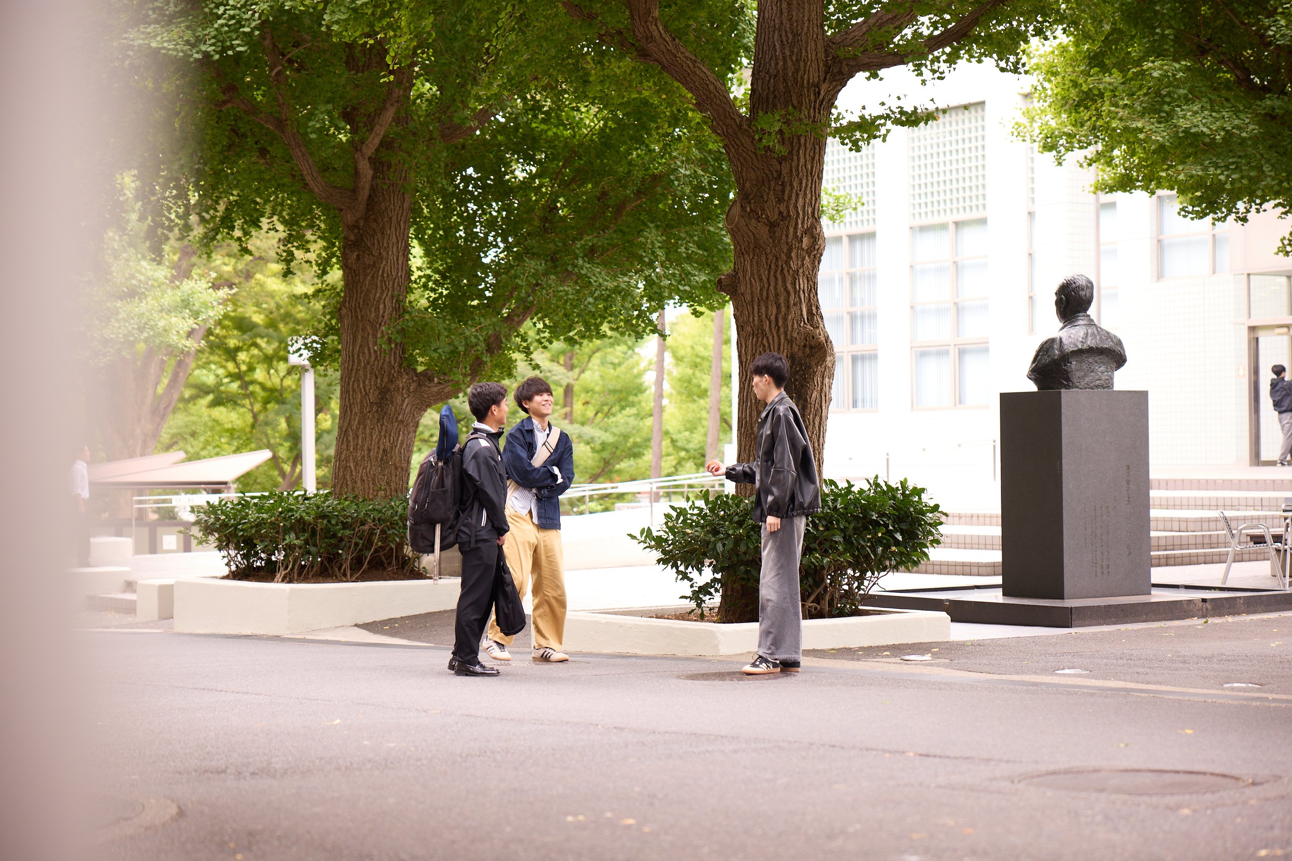 Photo of three students in friendly conversation at Hiyoshi Campus