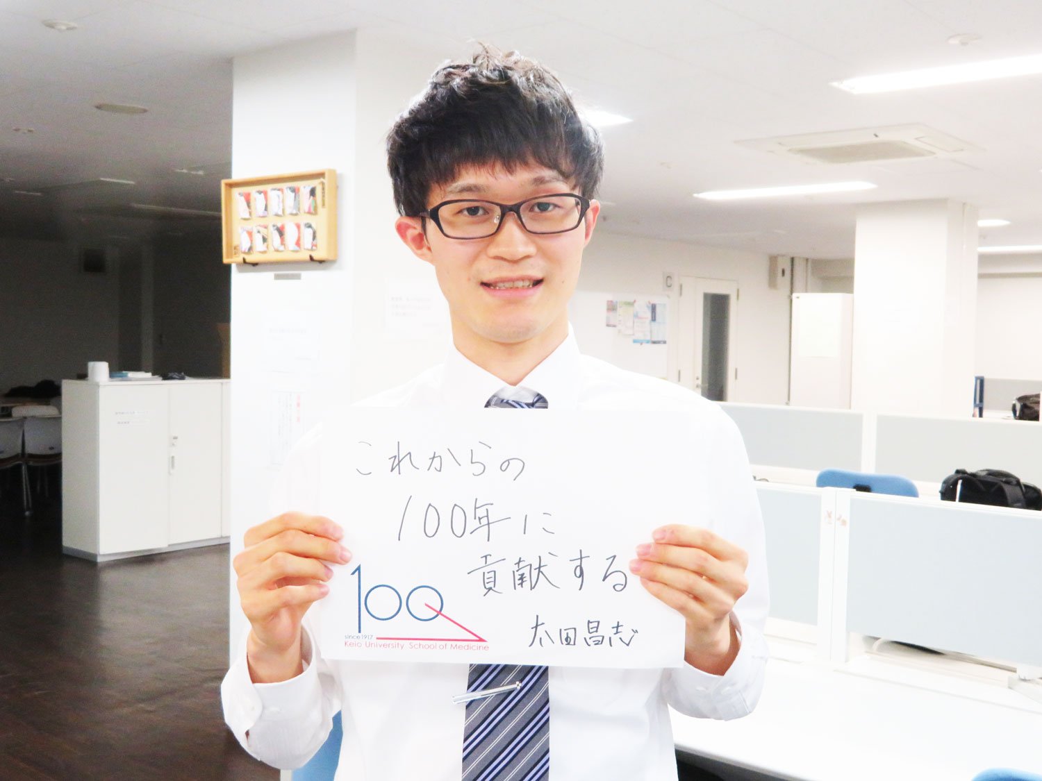 Masashi Ota holding a message