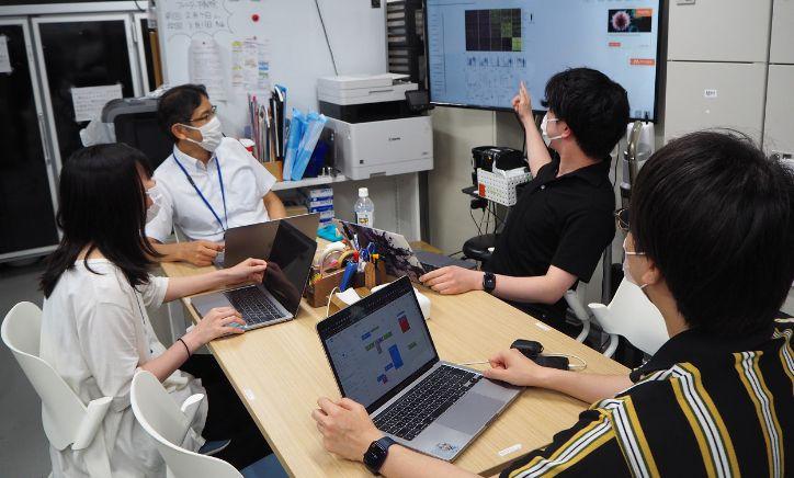 A discussion scene in Professor Hase's laboratory