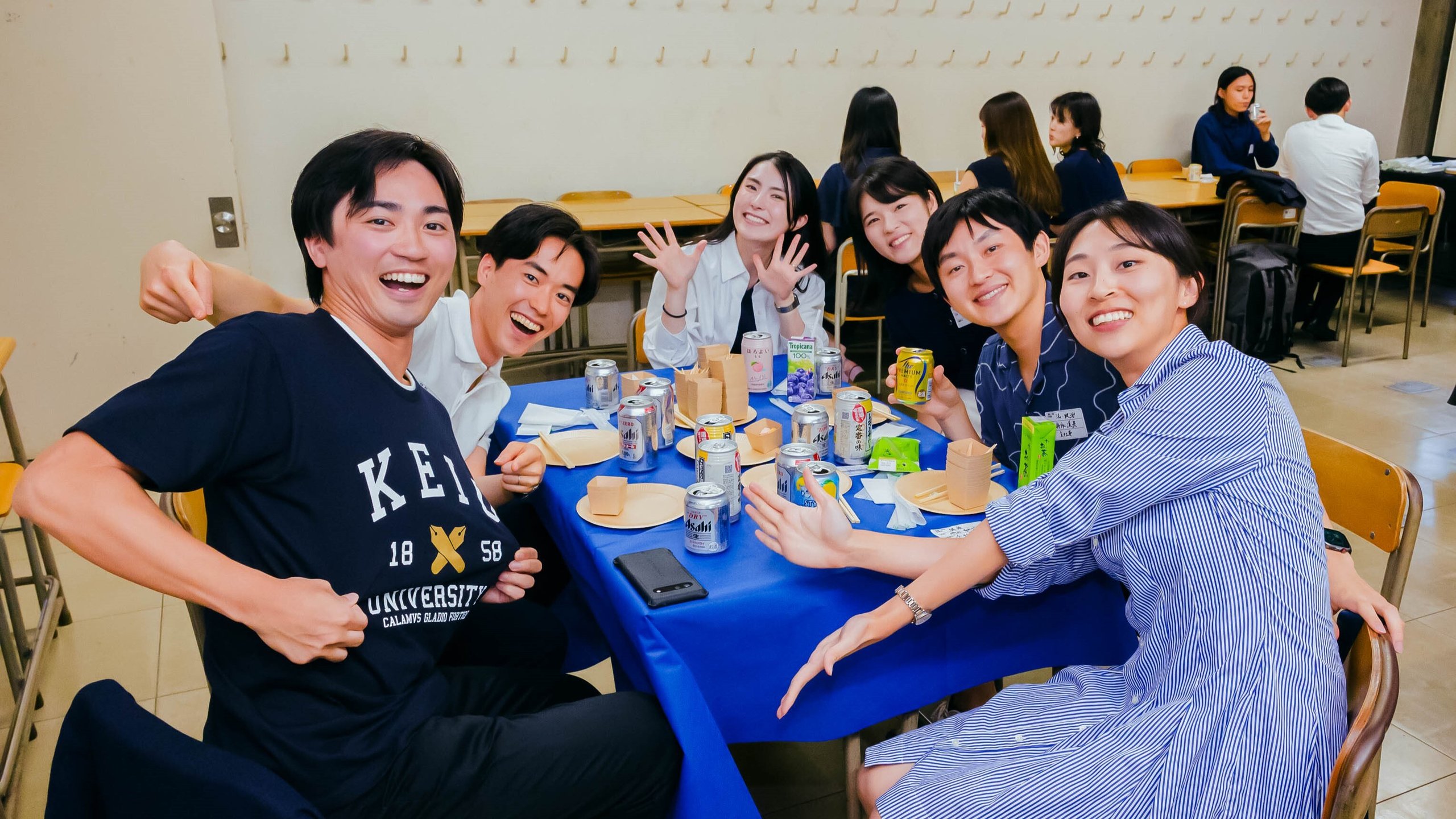 卒業5年塾員招待会の参加者たち。福引で景品が当たり、笑みを浮かべる。