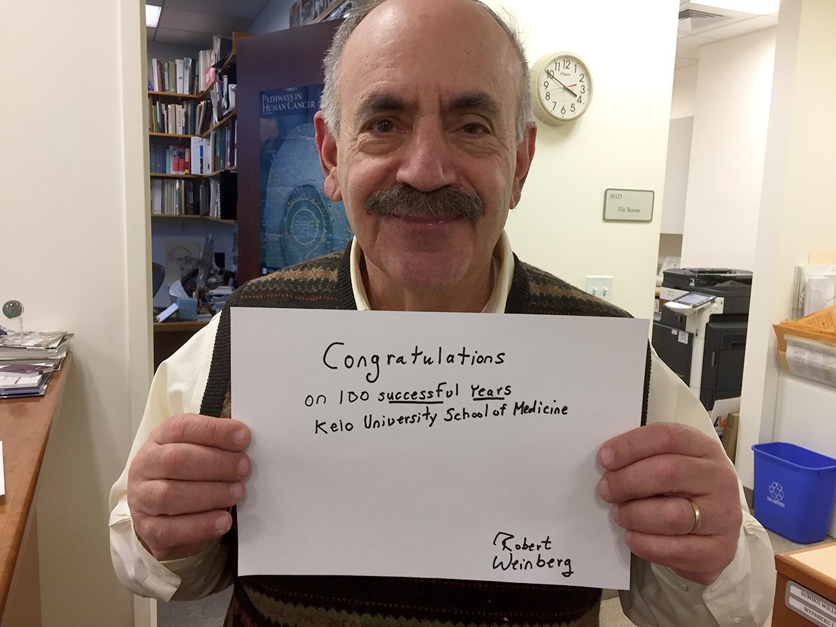 Robert A. Weinberg holding a message