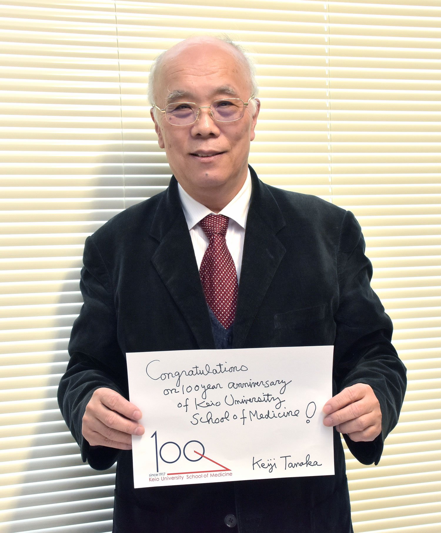 Keiji Tanaka holding a message