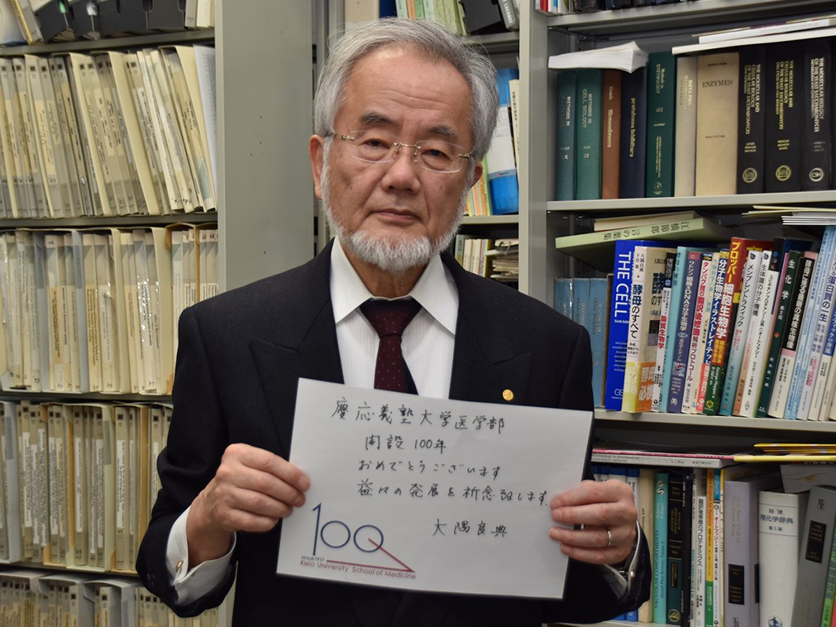 Yoshinori Ohsumi holding a message