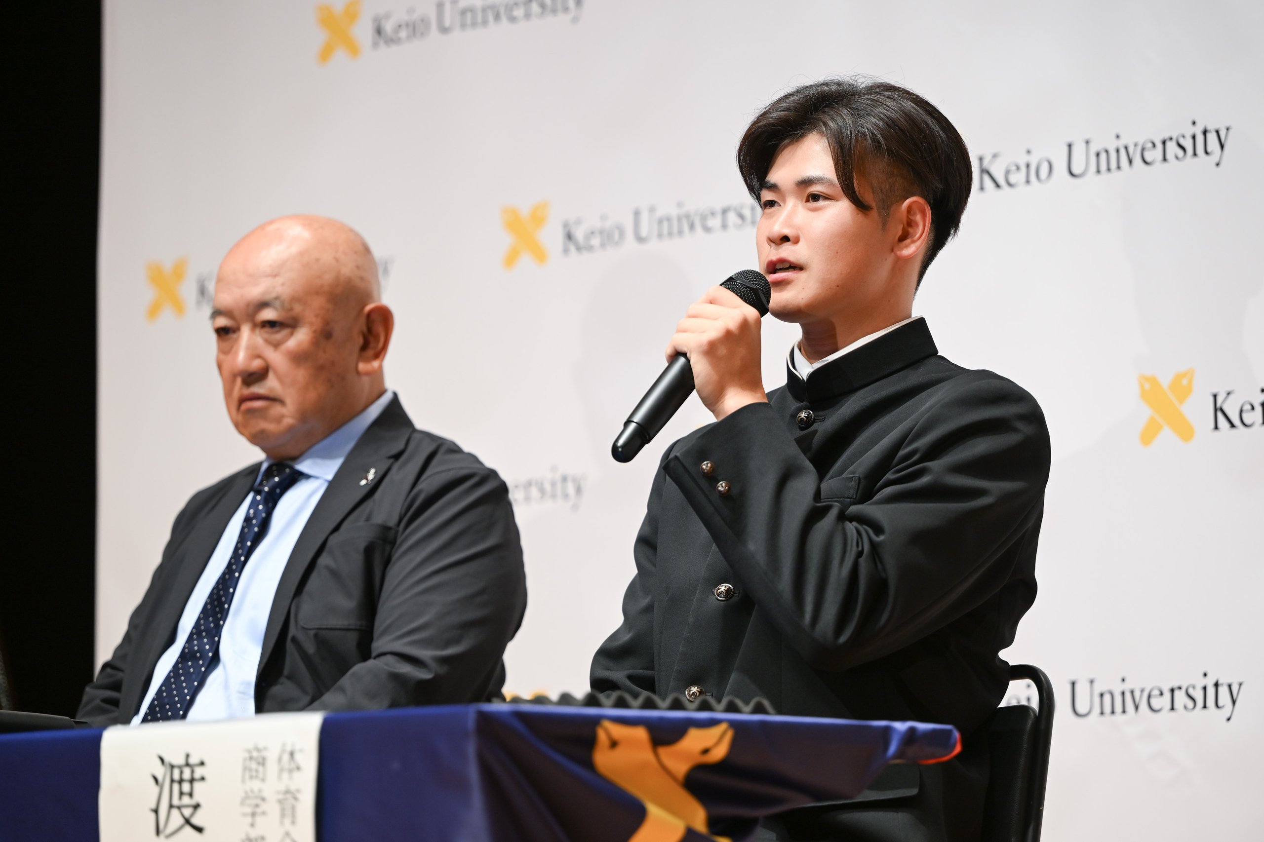 堀井哲也監督とともに記者会見を受け指名の喜びと今後の抱負を述べる渡辺君の写真